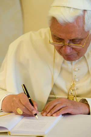 The Pope signing Caritas in Veritate