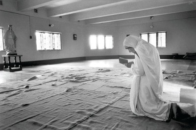Mother Teresa kneeling to pray before Virgin Mary